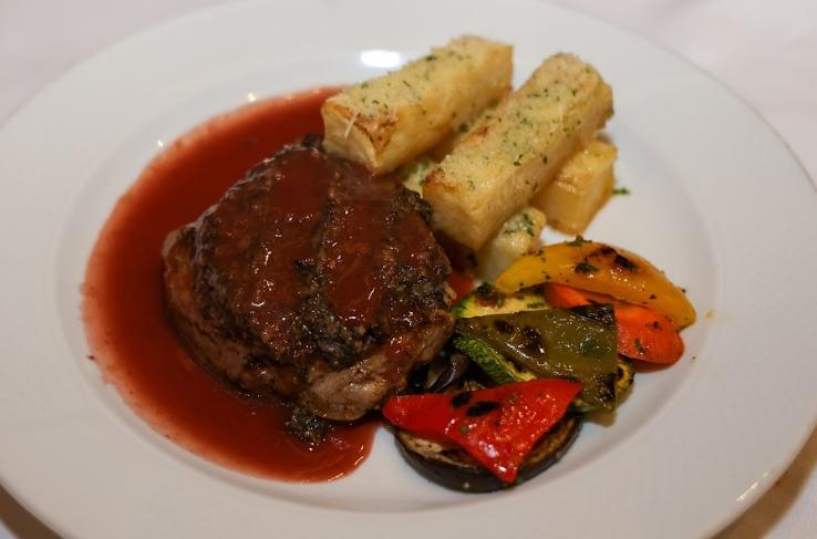 Medallón de res relleno de espinacas en salsa de frutos rojos y duxxelles, papa pont neuf y verduras parrilla